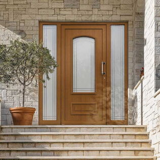 WERU Kunststoff Haustür AVIDA H10323 in Farbe 09 Golden-Oak mit zwei verglasten Seitenteilen, klassisches Modell mit Zierrähmchen und Lichtausschnitt mit bogenförmigen Abschluss oben eingebaut in hell verklinkertem Hauseingang