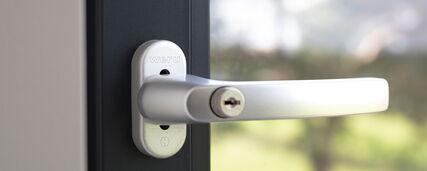 Nahaufnahme abschliessbarer Fenstergriff silber an schwarzem Fenster