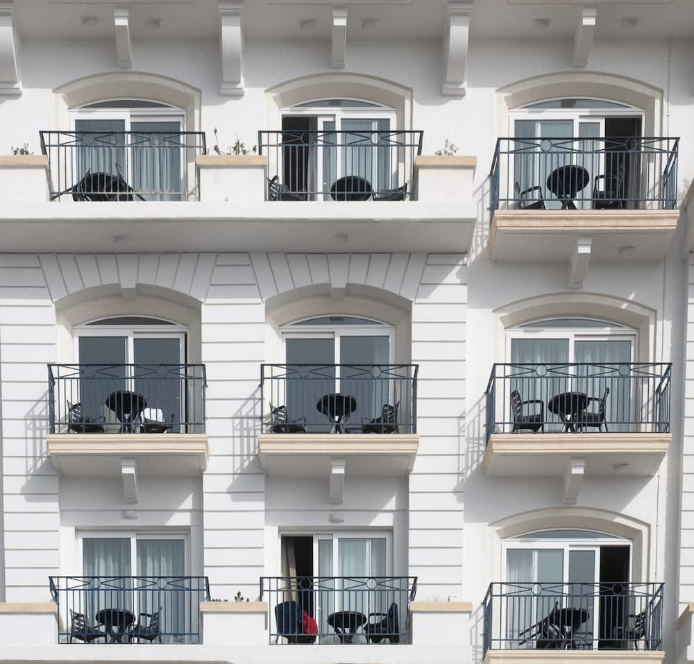 Mehrfamilienhaus Altbau mit modernen weißen Kunststofffenstern und schwarzem Balkongeländer